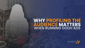 A digital out-of-home (DOOH) advertisement image with a dark blue overlay over the busy streets of Quiapo. On the left, a semi-transparent, white silhouette of a person's head and shoulders is visible, overlaying the image of old buildings. The main text in the center right is white and orange, reading: "WHY PROFILING THE AUDIENCE MATTERS WHEN RUNNING DOOH ADS". The bottom right corner features a logo for NYXSYS PHILIPPINES. The background shows heavy traffic on a multi-lane street, numerous billboards above the buildings and streets, and a general urban, slightly overcast atmosphere.